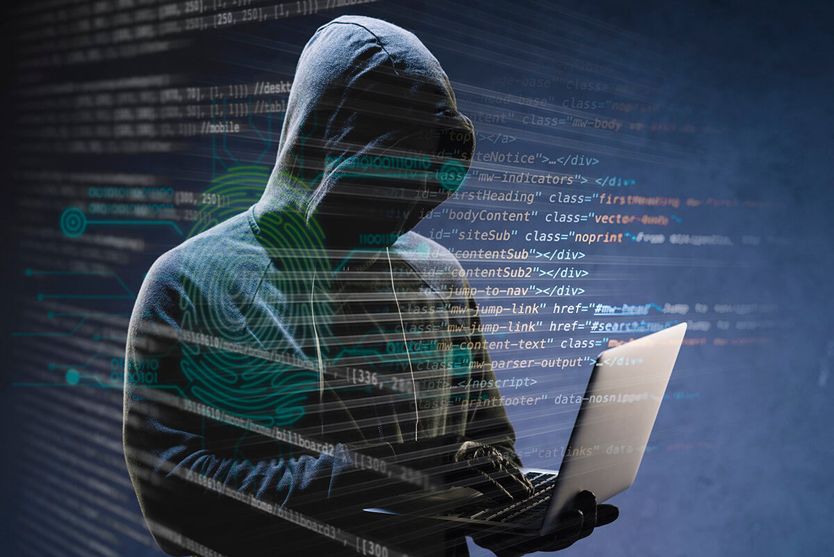 An anonymous person on a laptop with coding overlayed.